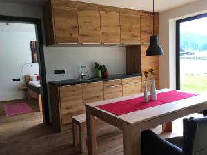 a kitchen with a wooden table and a dining room at Ferienwohnung Berglieb in Oberstdorf