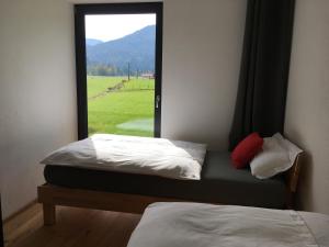 two beds in a room with a window at Ferienwohnung Berglieb in Oberstdorf