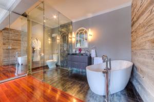 a bathroom with a tub and a glass shower at Downtown Luxury Victorian Retreat in Toronto