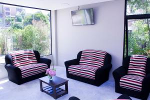 a living room with two chairs and a table at San Remo Viking Hotel in Pinamar