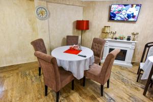 a dining room with a table with chairs and a fireplace at Noblesse House in Deva