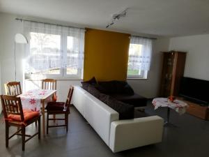 a living room with a white couch and a table at Ferienwohnung, Monteurwohnung in Hauswalde