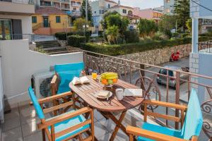 drewniany stół i krzesła na balkonie w obiekcie Elena's apartment 4 w mieście Argostoli