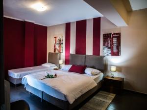 a bedroom with two beds with red and white stripes at Gina's Studios in Aliveri