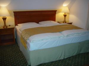 a large bed in a hotel room with two lamps at das "Village House" in Volkse in Volkse