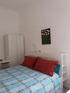 um quarto com uma cama com almofadas vermelhas em Casa Ida em Donnalucata
