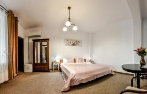 a white bedroom with a bed and a table at Noblesse Deva in Deva
