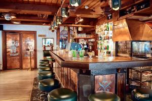 eine Bar mit einer Reihe von Hockern in einem Restaurant in der Unterkunft Chalet Hotel Adler AG in Kandersteg
