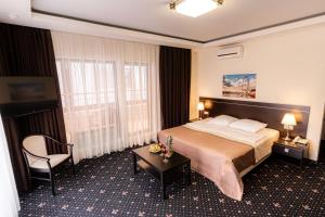 une chambre d'hôtel avec un lit et une chaise dans l'établissement Inter Hotel, à Samara