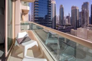 a balcony with two white chairs and a view of a city at Wow! Super Luxury Apartment in Dubai Marina - 1BR RO in Dubai