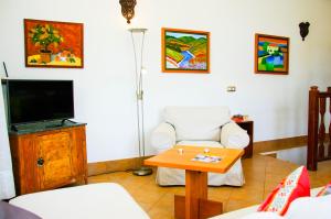 a living room with a tv and a table at Casa Rural Villa Lola Y Juan in Haría