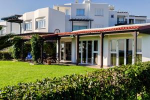 ein Haus mit grünem Rasen davor in der Unterkunft Blue Bay Beach House in Larnaka