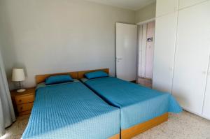a bedroom with two beds with blue sheets at Blue Bay Beach House in Larnaca