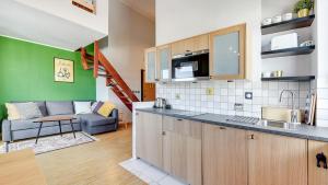 eine Küche und ein Wohnzimmer mit einem Sofa in der Unterkunft Dom & House - Apartment Smart Studio Sopot in Sopot