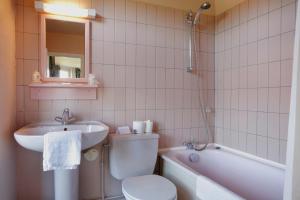維桑的住宿－貝爾維尤酒店，浴室配有盥洗盆、卫生间和浴缸。