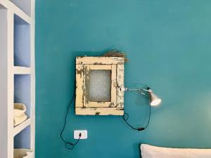 Habitación azul con espejo en la pared en Capannacce Organic and Horse Farm, en Rapolano Terme