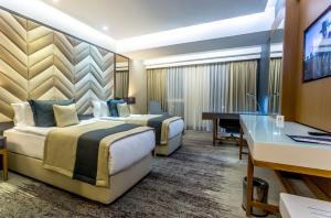 Pokój hotelowy z 2 łóżkami i biurkiem w obiekcie Willmont Hotel w mieście Balıkesir