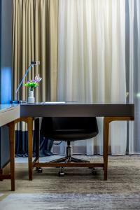- un bureau noir avec une chaise devant un rideau dans l'établissement Willmont Hotel, à Balıkesir