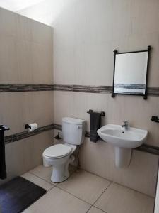 a bathroom with a toilet and a sink at The Shakespeare Inn in Vanderbijlpark