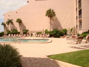 a pool with chairs and umbrellas next to a building at Siesta Breakers #603, Gulfside in Siesta Key, FL in Siesta Key