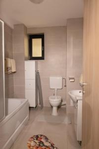 a bathroom with a white toilet and a sink at Studio Ambiance , Mamaia in Mamaia Nord