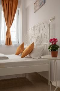 a white bed with orange pillows and a window at Studio Ambiance , Mamaia in Mamaia Nord