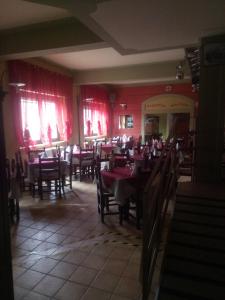 uma sala de jantar com mesas e cadeiras e paredes vermelhas em London Cafè em Castelnovo neʼ Monti