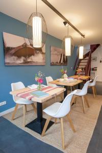 een eetkamer met 2 tafels en witte stoelen bij Mid83 in Woudsend