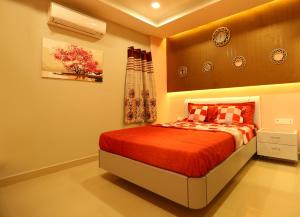 a bedroom with a bed with a red comforter at Babukala Regency in Kanchipuram