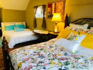 a bedroom with two beds and a table with a lamp at The Sunshine House-Free Parking in Vancouver