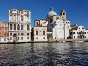 eine Gruppe von Gebäuden neben einem Wasserkörper in der Unterkunft Corte dei Bari in Venedig