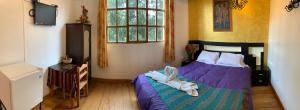 um quarto com uma cama com sapatos em Hostal Qolqampata em Cusco