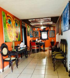 eine Frau, die auf einem Klavier in einem Raum mit orangefarbenen Wänden sitzt in der Unterkunft La Posada del Arcangel in Managua