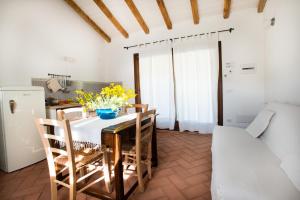 a kitchen with a table and chairs and a refrigerator at Case Vacanze S'Arrexina in Rudalza +30 photos