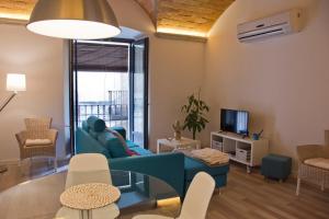 sala de estar con sofá azul y TV en Can Pauet Apartaments en Palamós