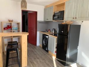 una cucina con frigorifero nero e bancone di Appartement de vacances à Isola 2000 a Isola 2000