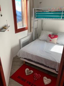 um pequeno quarto com uma cama com corações no chão em Appartement de vacances à Isola 2000 em Isola 2000