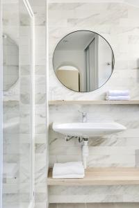 a bathroom with a sink and a mirror at Hotel Courseine in Courbevoie