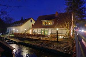 ein Haus mit Lichtern am Fenster in der Nacht in der Unterkunft Apartment 5 - Gourmetzimmer in Bestensee