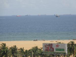 a sign on the beach with ships in the water at Rosalie's Suites in Lomé