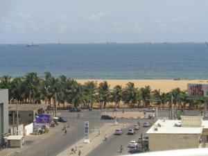a view of a street with palm trees and the beach at Rosalie's Suites in Lomé