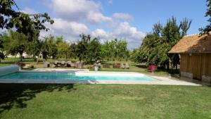 a swimming pool in the yard of a house at Chambre d'hotes de la Vallee in Montaure