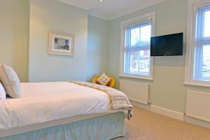 a bedroom with a bed and a flat screen tv at St Mary's Cottage in Eastbourne