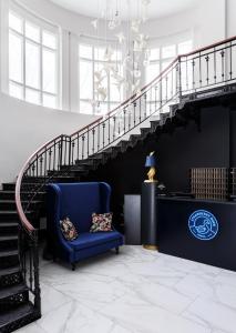 a staircase leading up to a balcony with a blue couch at Strawberry Duck Moscow in Moscow