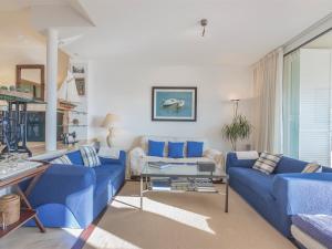 una sala de estar con sofás azules y una mesa. en Casa pilar en S'Agaró