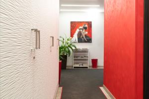 a hallway with a red door and a painting on the wall at B&B La Maison de Jo in Rome