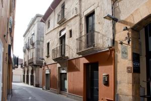 an empty street in a city with buildings at Can Pauet Apartaments in Palamós