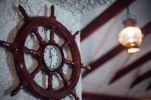 une horloge en bois sur un mur avec une lumière dans l'établissement Hotel Laxnes, à Mosfellsbær