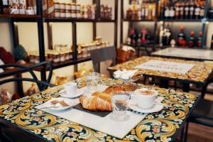 ローマにあるB&B La Maison de Joのクロワッサンとコーヒーが入ったテーブル
