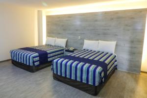 duas camas sentadas uma ao lado da outra num quarto em Mallorca Hotel  em Cidade do México
